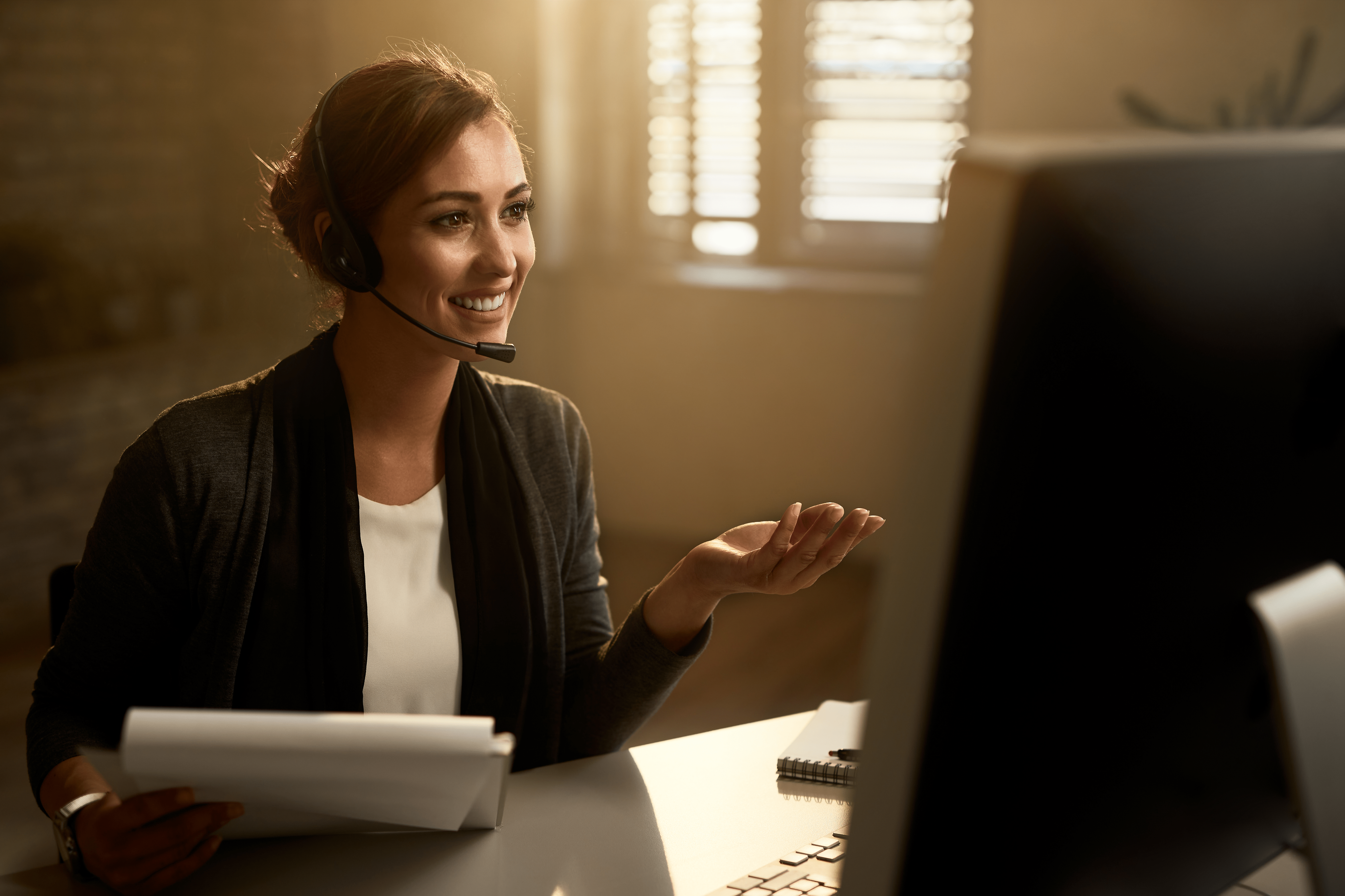 happy-customer-service-representative-using-computer-while-communicating-with-clients-online-min